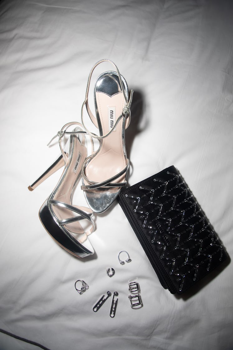 A close-up of Demi Singleton's silver Miu Miu sandals, a black purse and jewelry