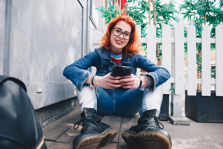 Young woman on her phone enjoying the April 2022 new moon in Aries, which affects her zodiac sign le...