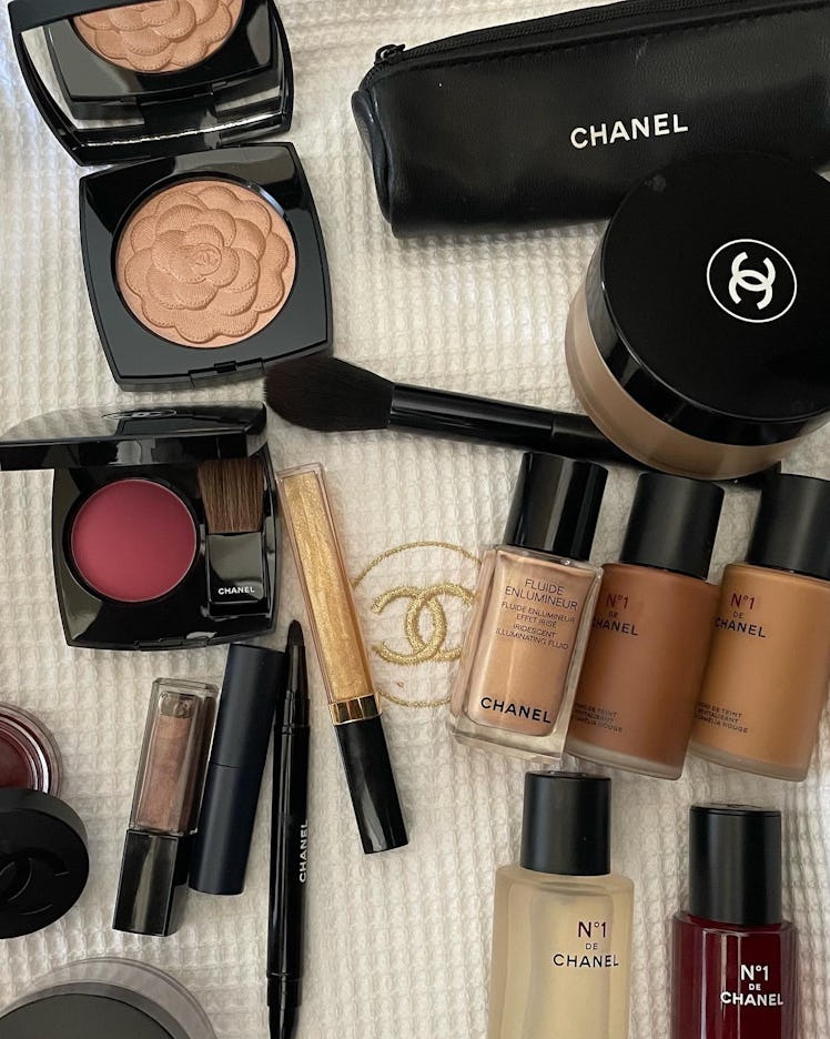 Various makeup products by Chanel laid out on a beige Chanel cover