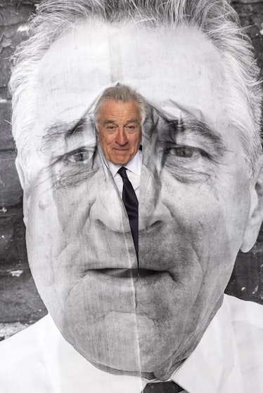 Robert DeNiro peeking out from an image of his face in a photo by JR