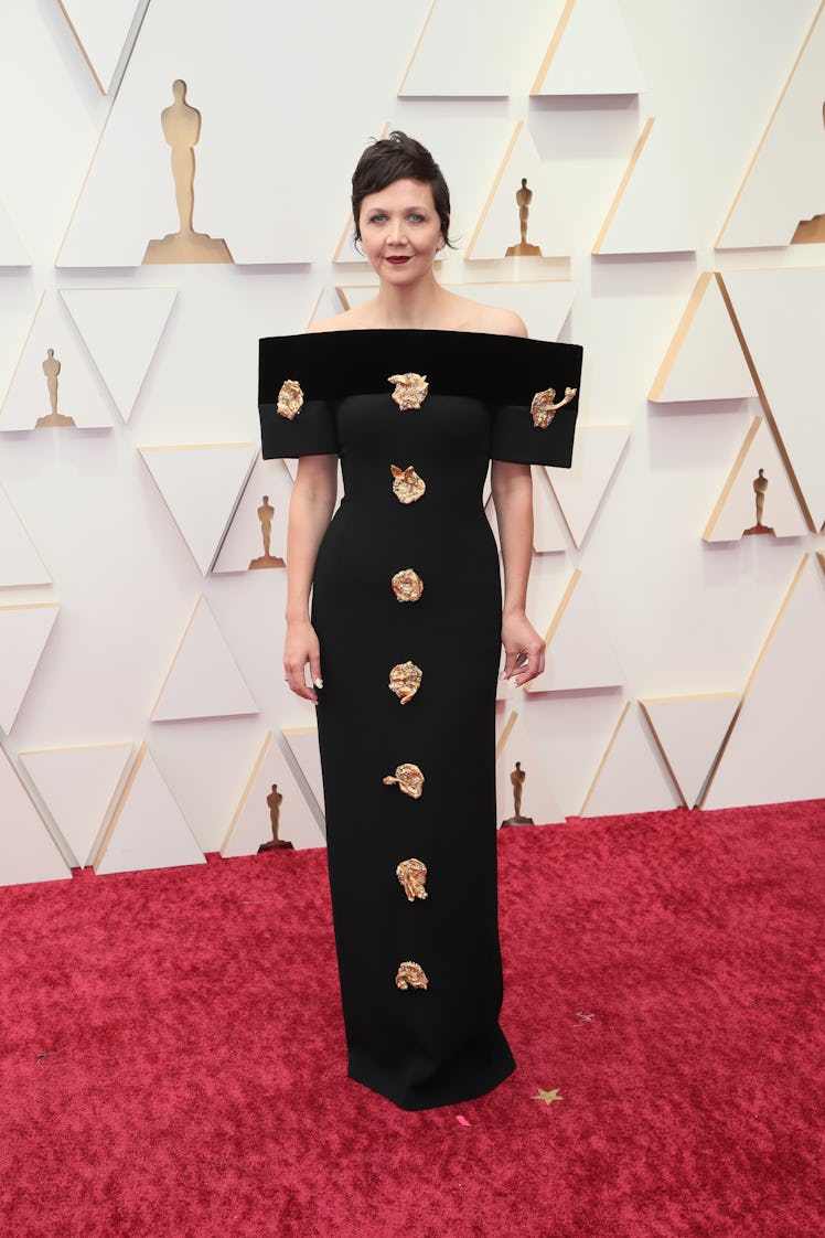 Maggie Gyllenhaal on the red carpet wearing a black Schiaparelli dress with gold details at the 2022...