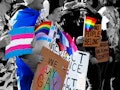 Teenagers holding LGBTQ+ pride flags, trans flags, and signs reading "Say Gay" protest Florida's "Do...