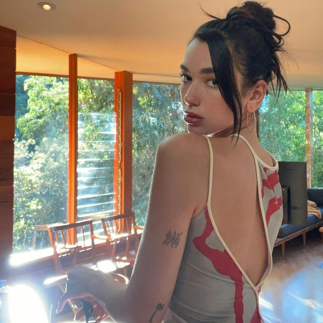 Dua Lipa wears her hair up in a messy bun.