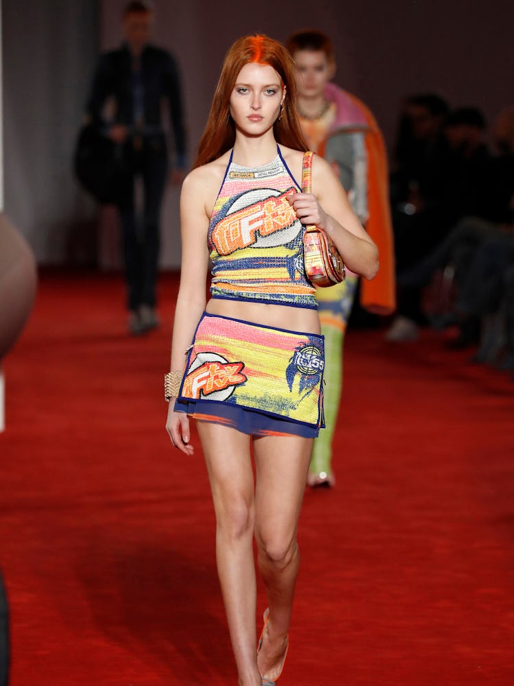 A model wearing a multicolored two piece outfit walks the Diesel runway