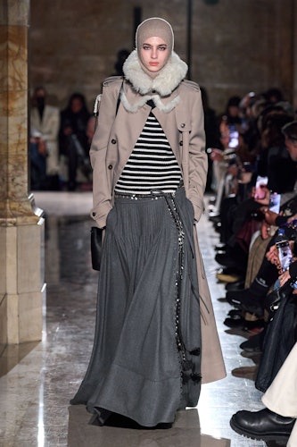 A model wearing a striped sweater, jacket, and long gray skirt from Altuzarra