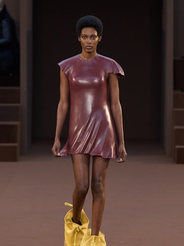 A model in a maroon dress and yellow boots by Loewe