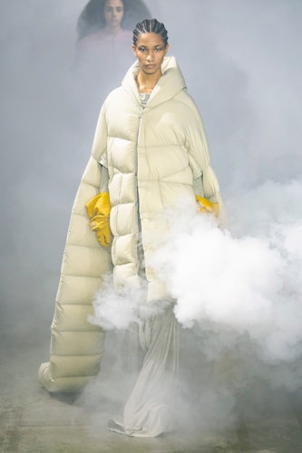 A model in a rick owens puff coat and yellow gloves