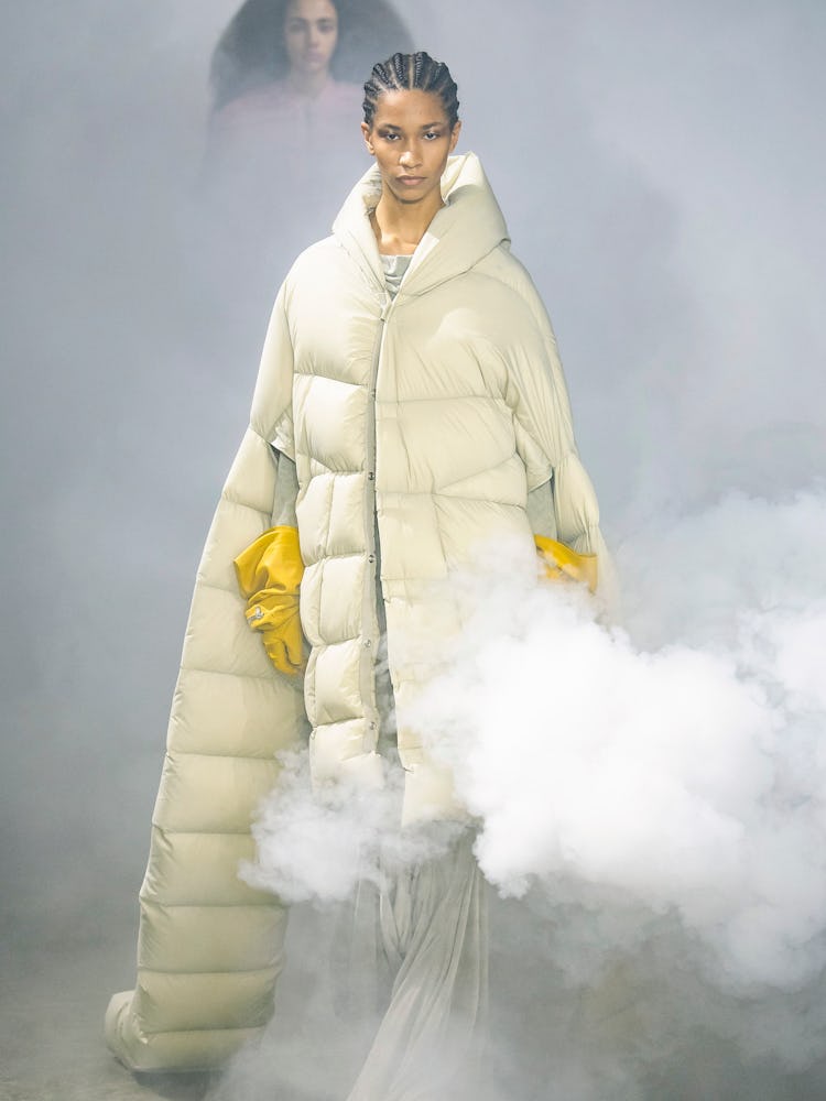 A model in a rick owens puff coat and yellow gloves