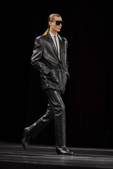 A model walking in a black leather Celine suit at the Men’s Fashion Week Fall 2022