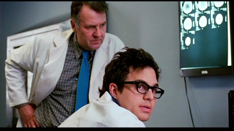 A doctor and his assistant examine brain scans in the movie