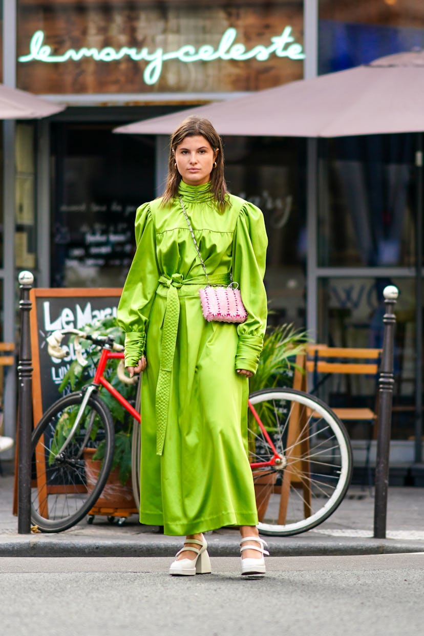 A girl wears a lime green, puffy-sleeved dress paired with a pink crossbody bag.