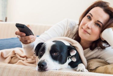 Woman watches TV with dog