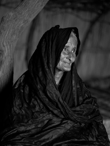 A woman a black shawl over her head and shoulders