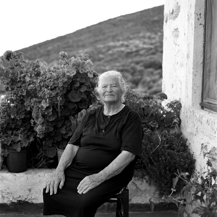 A woman seated in all black outside
