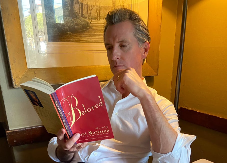 Gary Newsom sitting and reading the book 'Beloved' by Toni Morrison