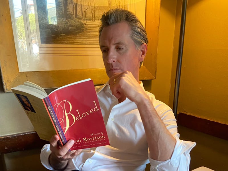 Gary Newsom sitting and reading the book 'Beloved' by Toni Morrison