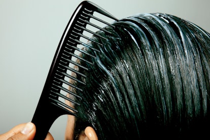 A woman with hair loss after COVID combing hair