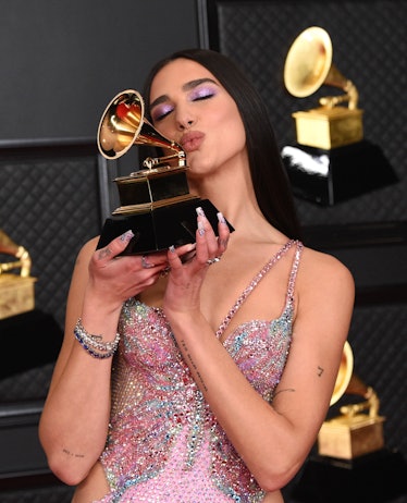 Dua Lipa holding up her Grammy Award at the 2021 Grammys