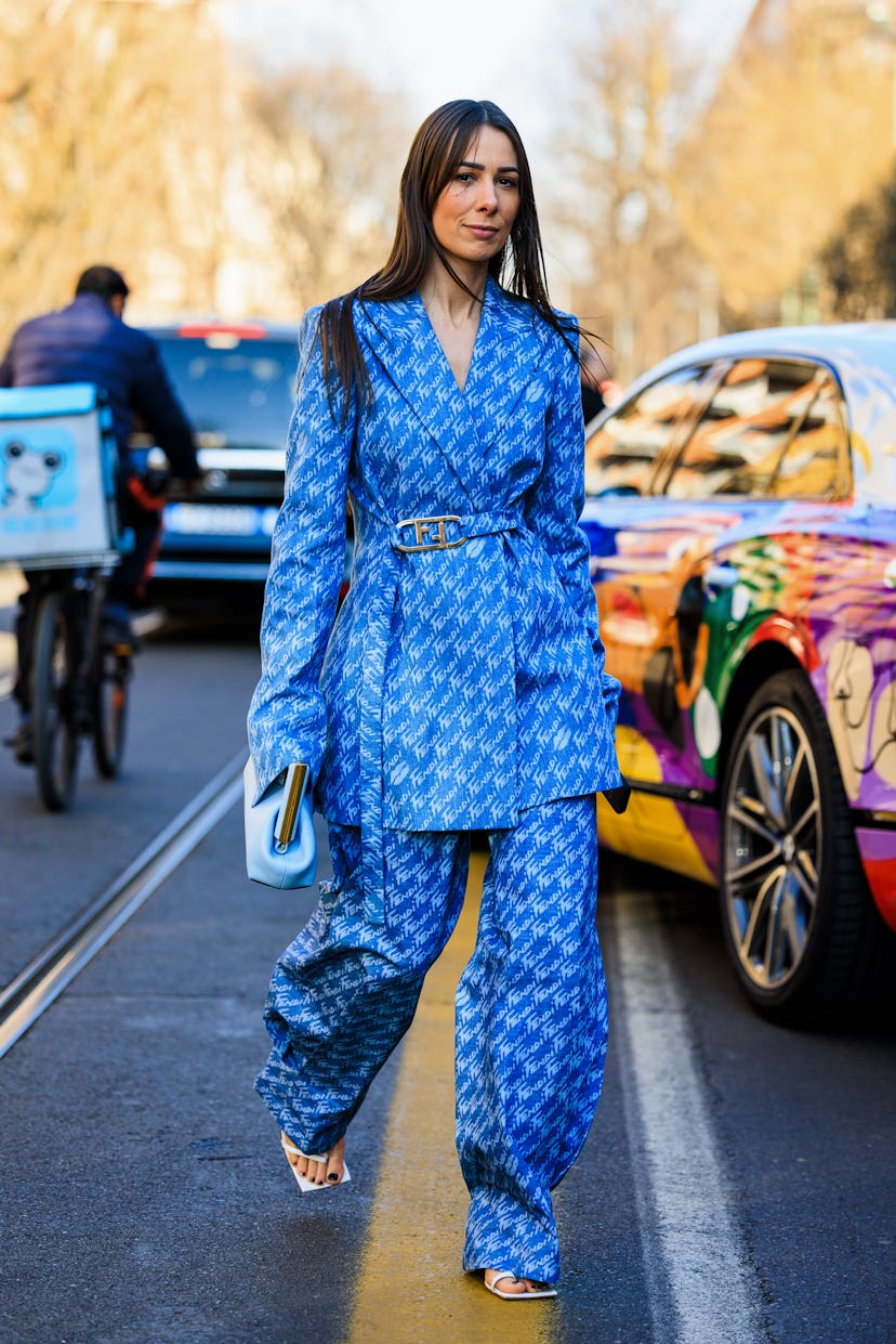 Guest at Milan Fashion Week in a two piece, blue, patterned suit. 