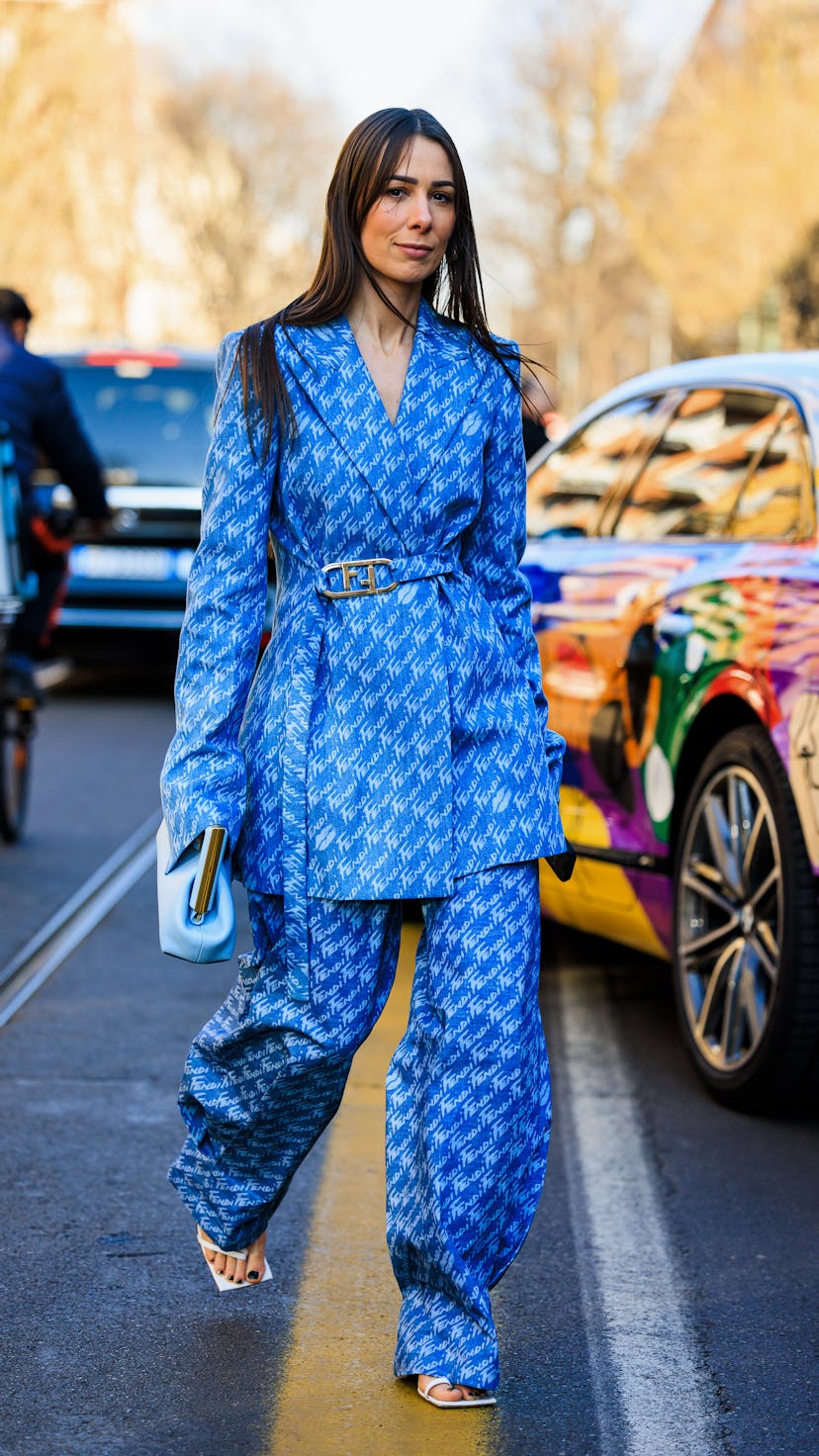 Guest at Milan Fashion Week in a two piece, blue, patterned suit. 