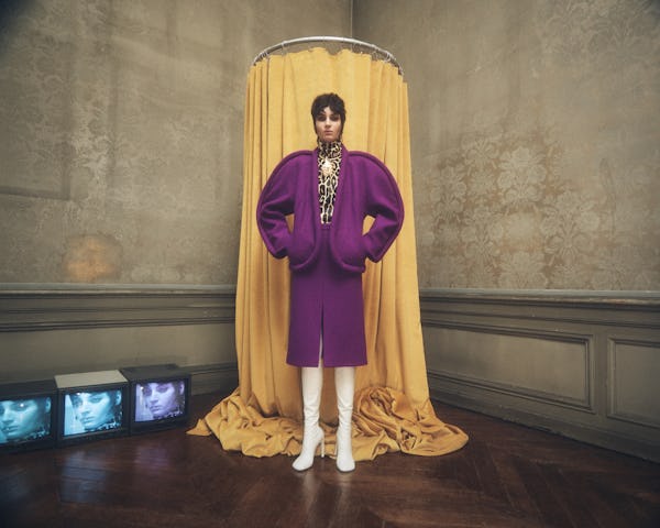 a model wearing a purple curved suit jacket and skirt by Dries Van Noten