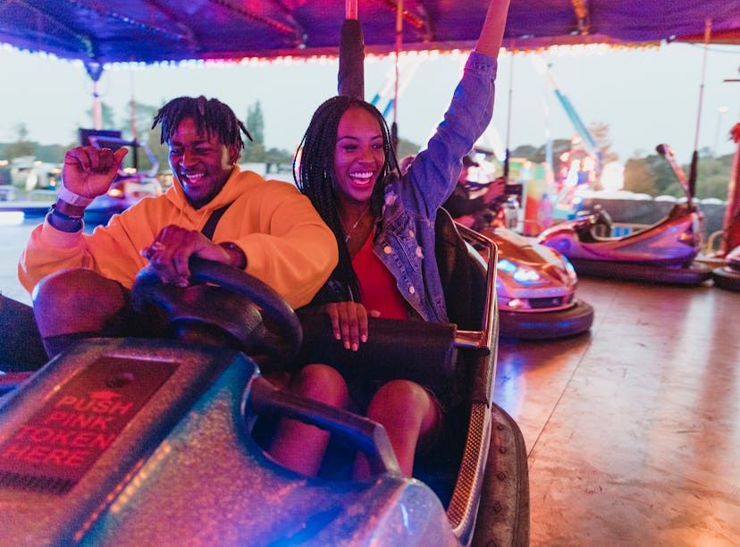 Young couple having fun in a bumper car the week of March 7, 2022, the best week for their lucky zod...