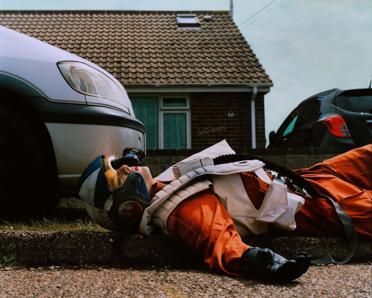 A woman lying on the road in a Space Suit cosplay costume by photographer Thurstan Redding