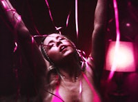 A still image from Euphoria showing Cassie dancing in a pink bathing suit amid pink streamers