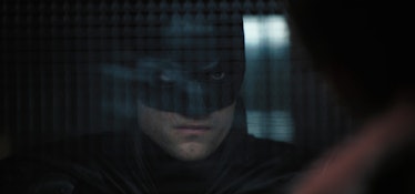 Batman (Robert Pattinson) looking at The Riddler (Paul Dano) in The Batman