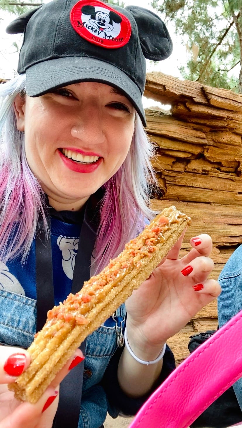 Tasting food at Disney's food and wine festival 2022 like this maple bacon churro.
