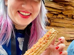 Tasting food at Disney's food and wine festival 2022 like this maple bacon churro.
