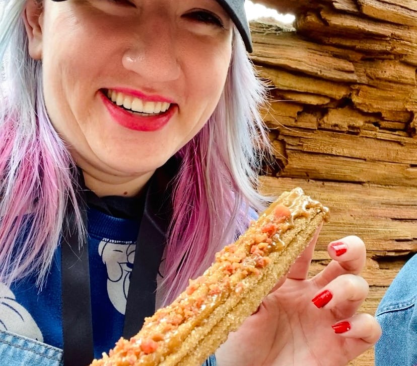 Tasting food at Disney's food and wine festival 2022 like this maple bacon churro.