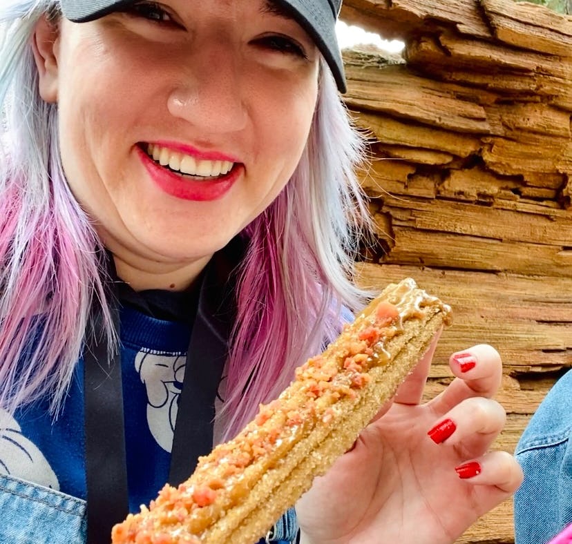 Tasting food at Disney's food and wine festival 2022 like this maple bacon churro.