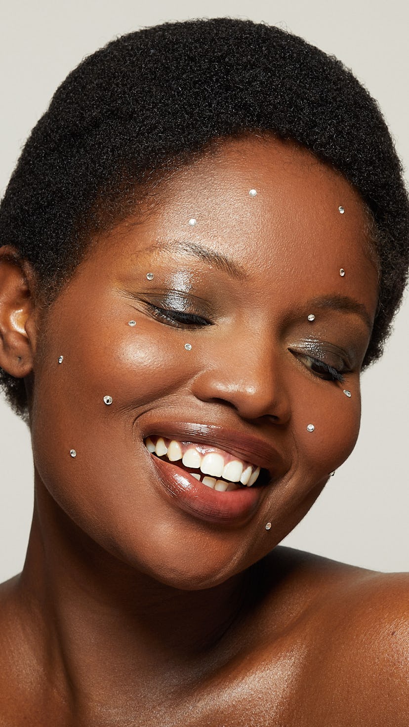 A woman with a pixie haircut with rhinestones on her face