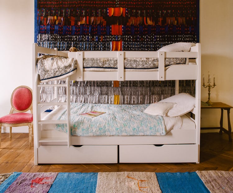 a child's bedroom with a bunk bed and a large work of art on the wall