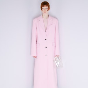 a model wearing a pastel pink duster coat by Nina Ricci