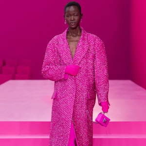 a model wearing a hot pink duster coat on the Valentino runway