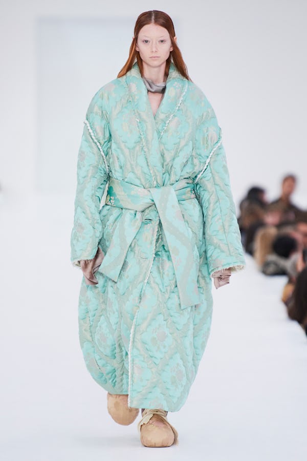 a model wearing a mint colored quilted coat by Acne Studios
