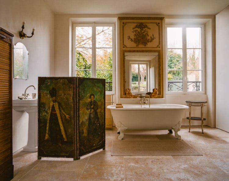 a bathroom with a folding screen in front of the bathtub