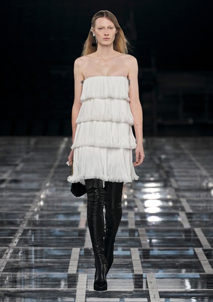 a model wearing a tiered white mini dress on the Givenchy runway