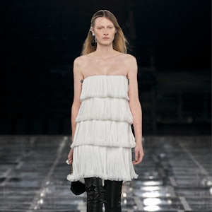 a model wearing a tiered white mini dress on the Givenchy runway