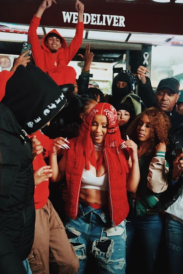 Cardi B with red hair printed like a bandanna on the set of a music video