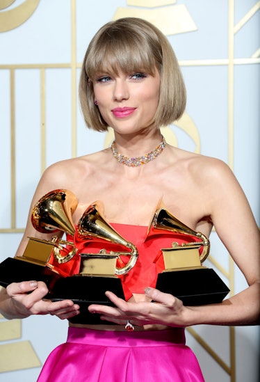 Taylor Swift holding her Grammy awards in 2016
