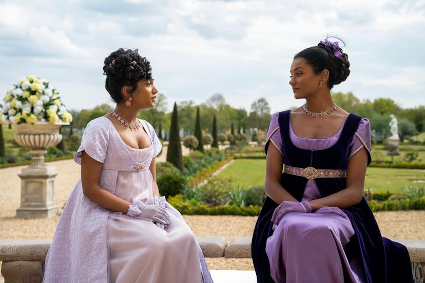 bridgerton season 2 cast seen sitting in a garden wearing purple dresses
