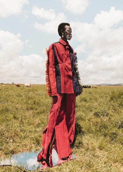 Model Gabriella Duduh standing in a field wearing a pantsuit from the Nigerian brand I.AM.ISIGO's fa...