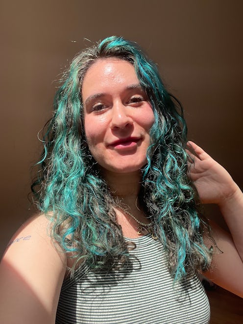 woman with curly blue hair and glowing skin