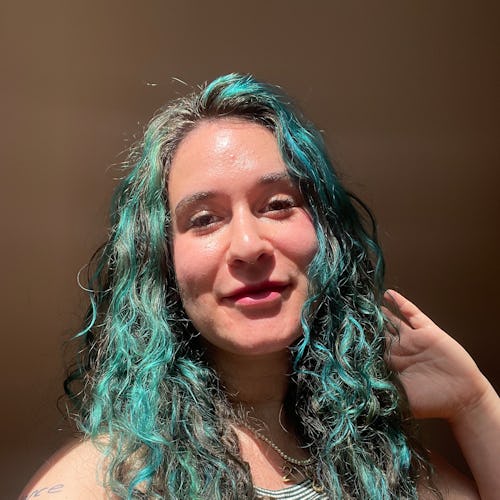 woman with curly blue hair and glowing skin