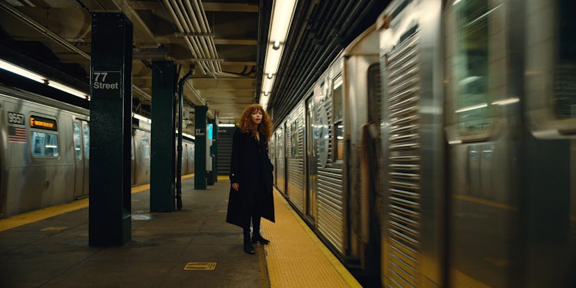 Natasha Lyonne in Russian Doll season 2 standing at a station as the subway passes next to her 
