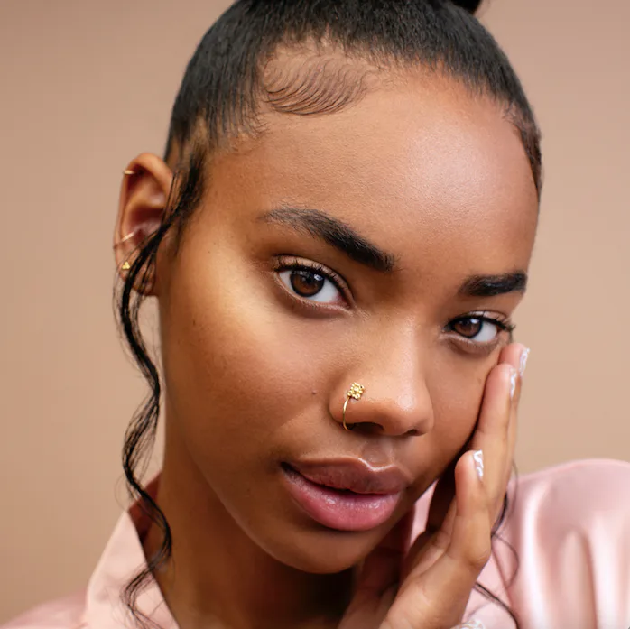 woman of color touching her face