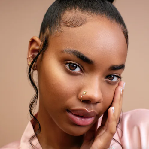 woman of color touching her face